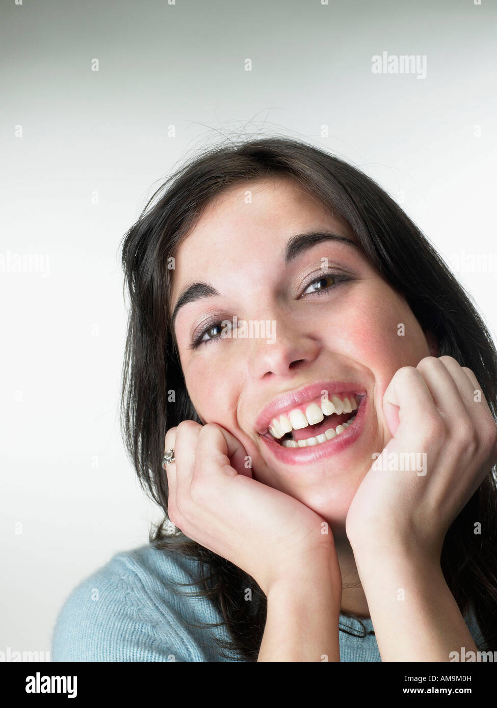 Woman smiling resting head on hands. Stock Photo