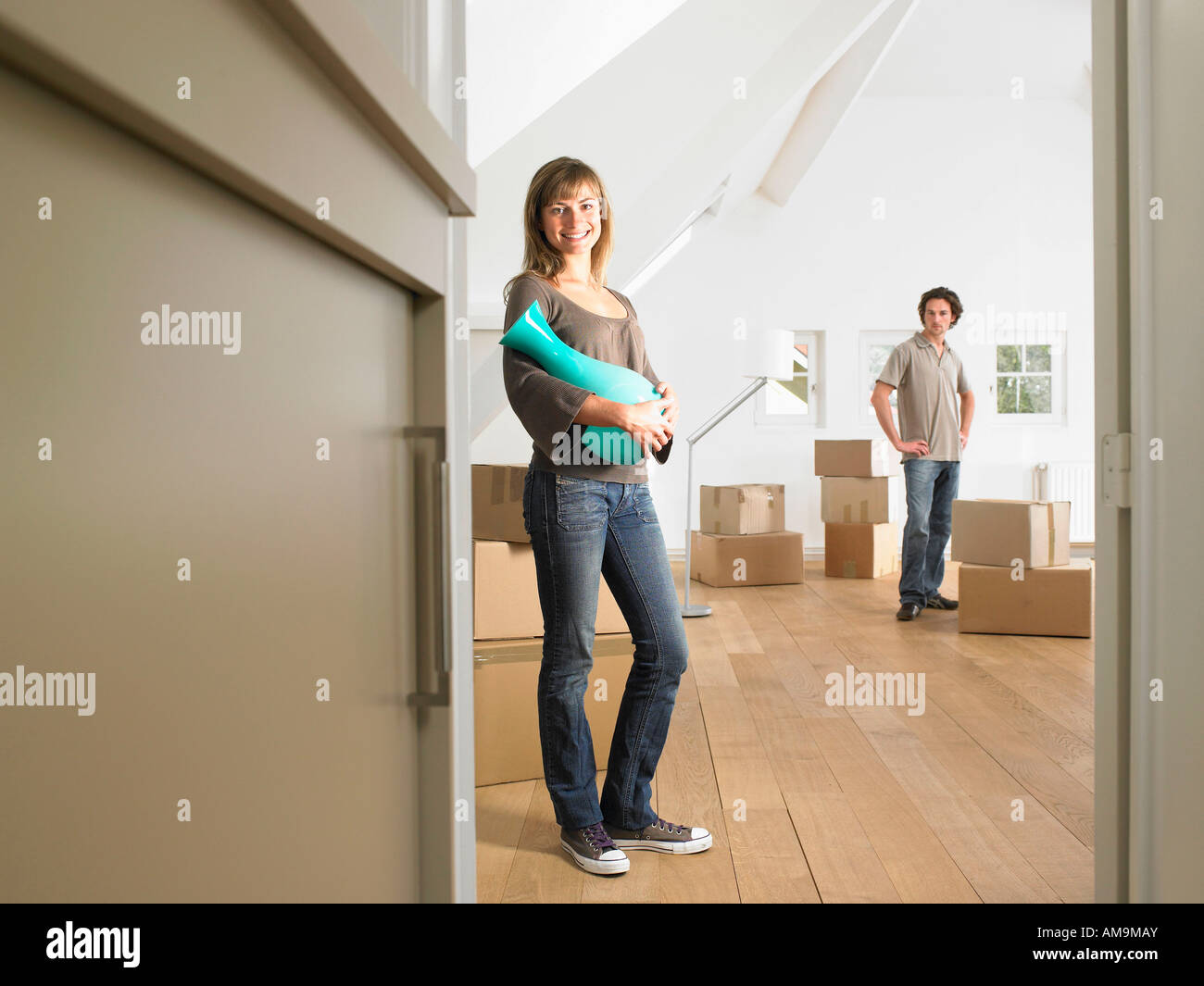 Couple moving into new home smiling Stock Photo - Alamy