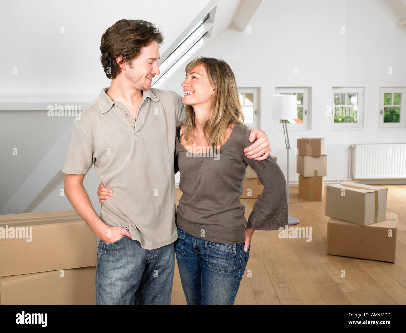 Couple moving into new home smiling Stock Photo - Alamy