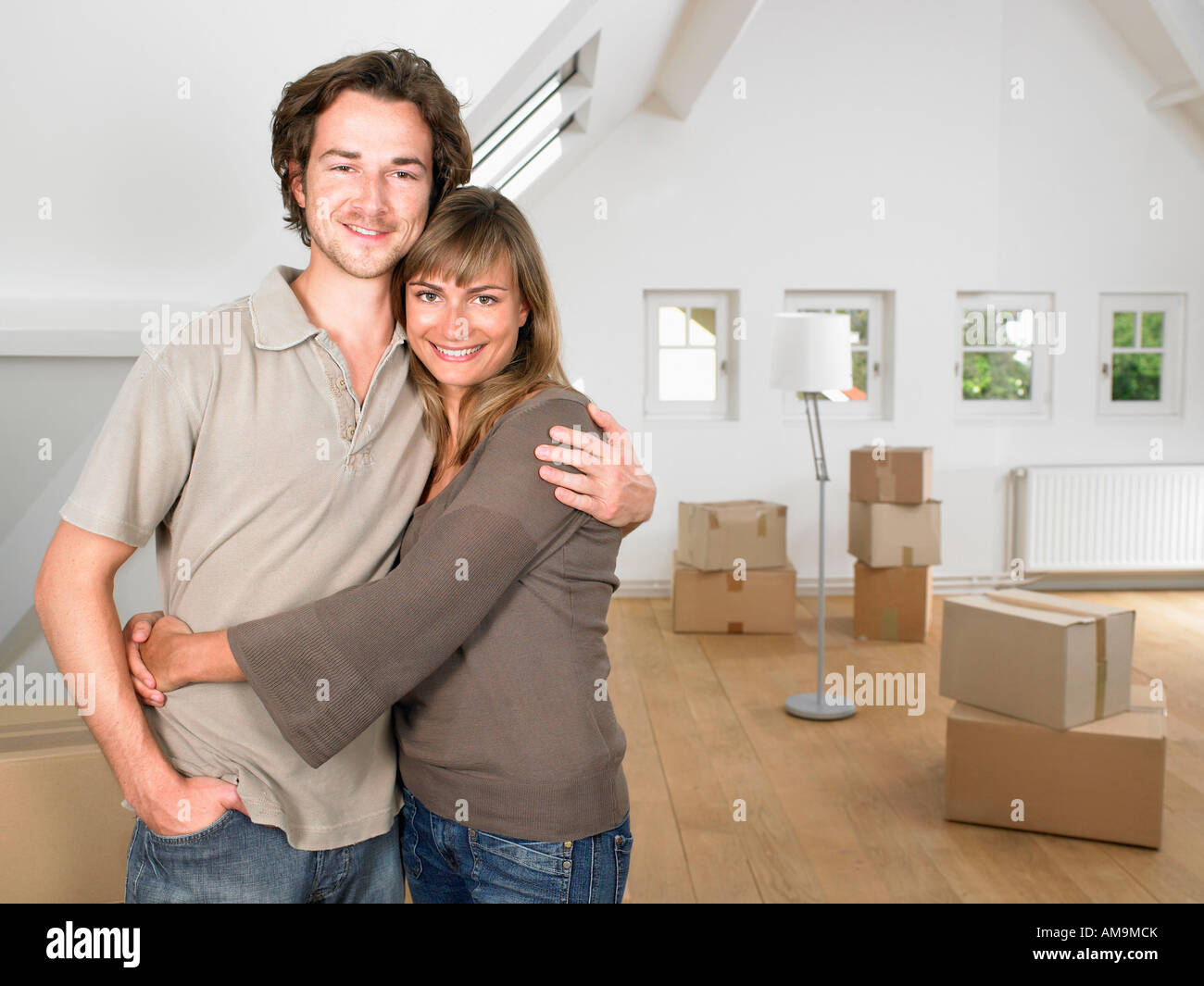 Couple moving into new home smiling Stock Photo - Alamy