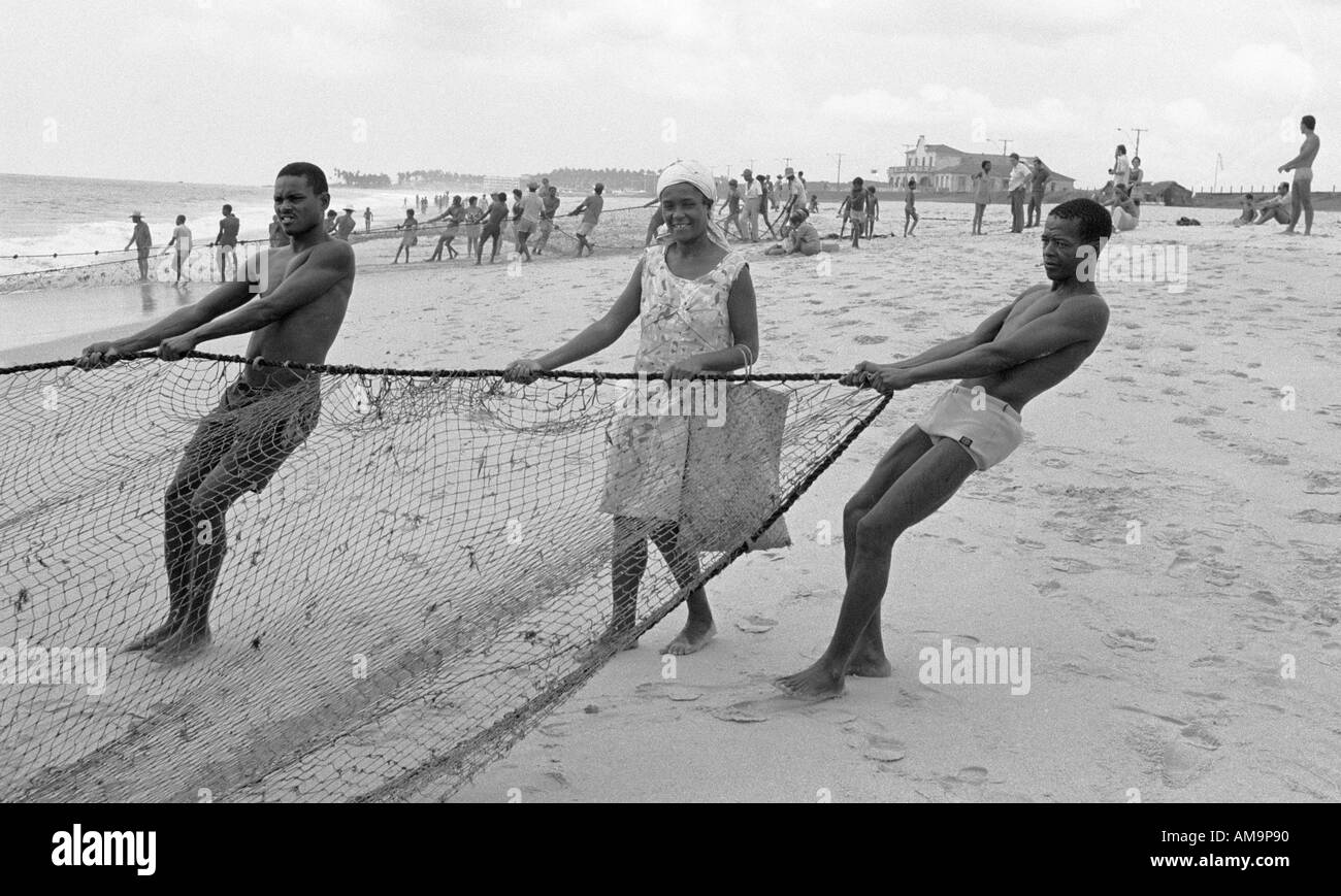 man and women pulling in the fishing nets from a small village in the State of Bahia in Brazil Stock Photo
