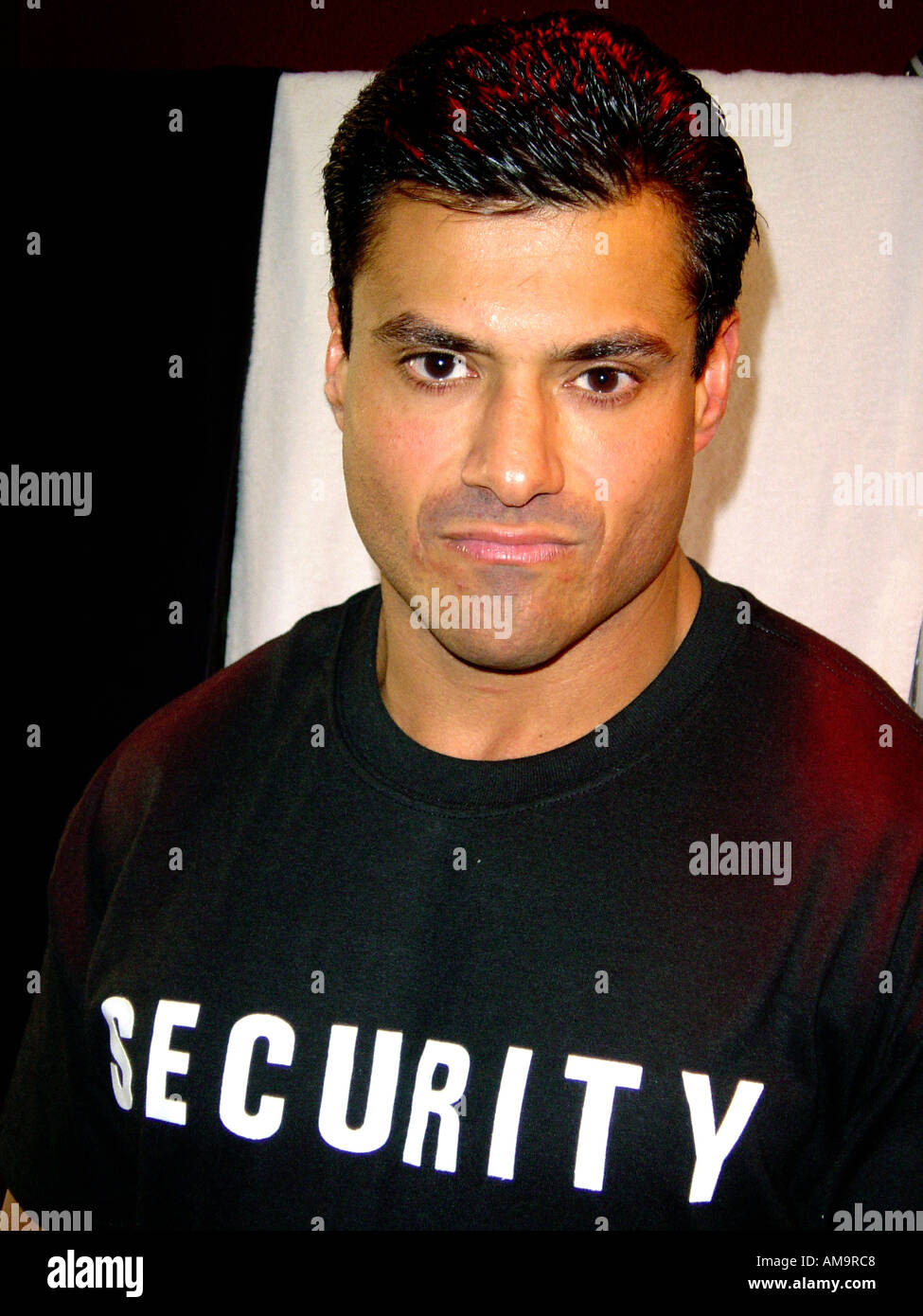 Portrait of a Male Security Guard or Bouncer of Hispanic Ethnicity Wearing a Black Tee Shirt Stock Photo