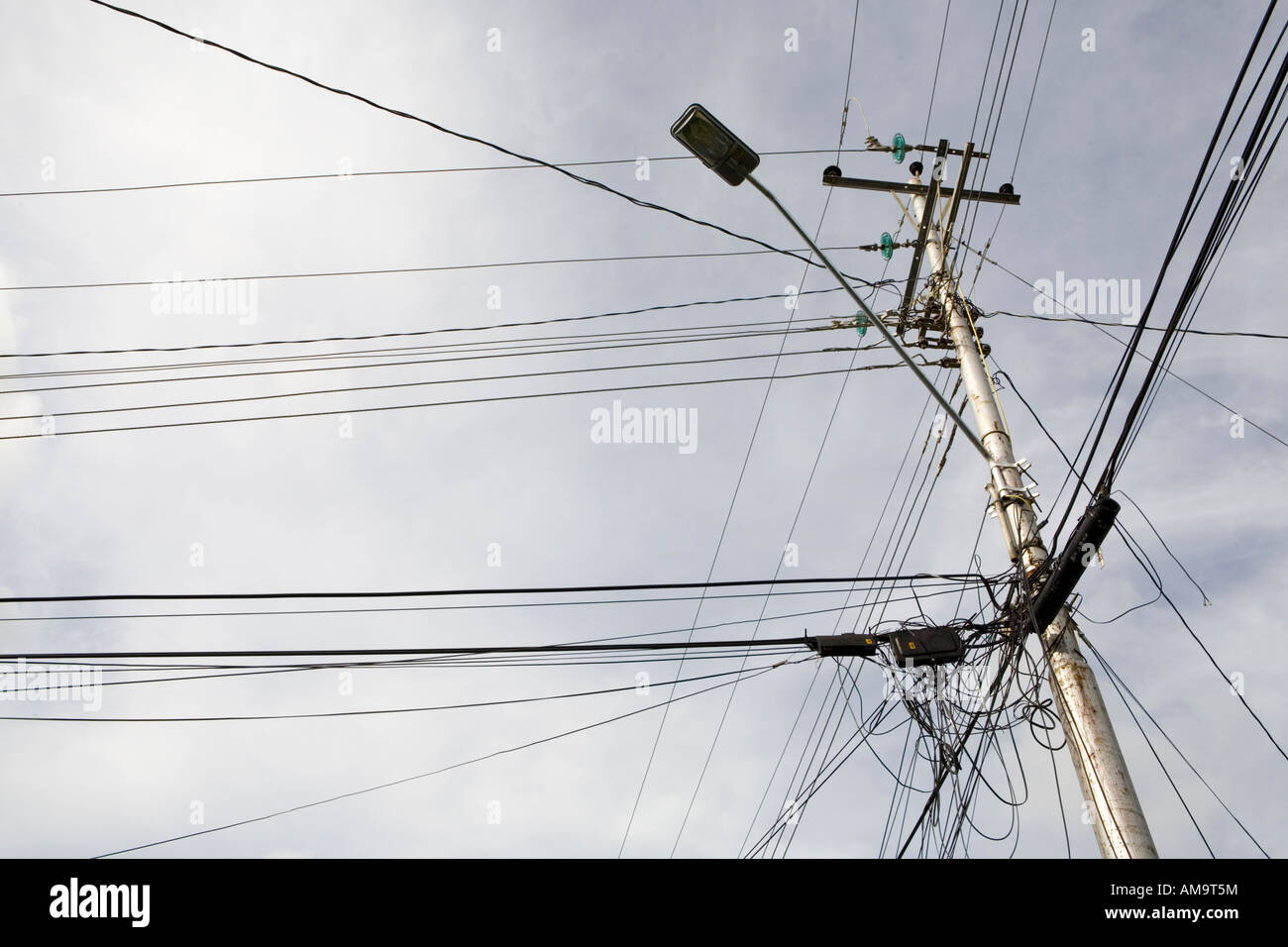 Overcrowded power lines against grey cloudy skies, Tobago Island Caribbean. Stock Photo