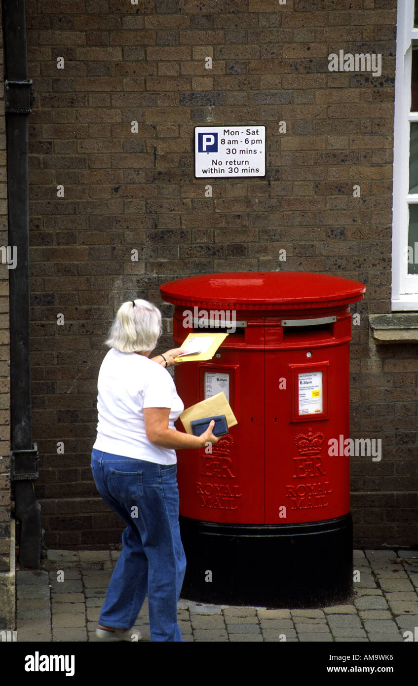 Person posting mail in double post box Great Malvern