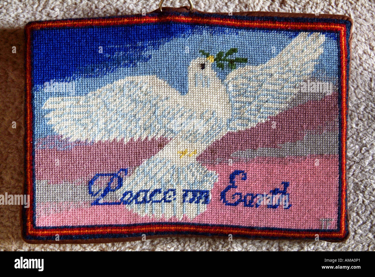 Prayer cushion kneel knelt pray worship embroider stitch fabric pad padded dove peace bird fly wing peace earth Stock Photo