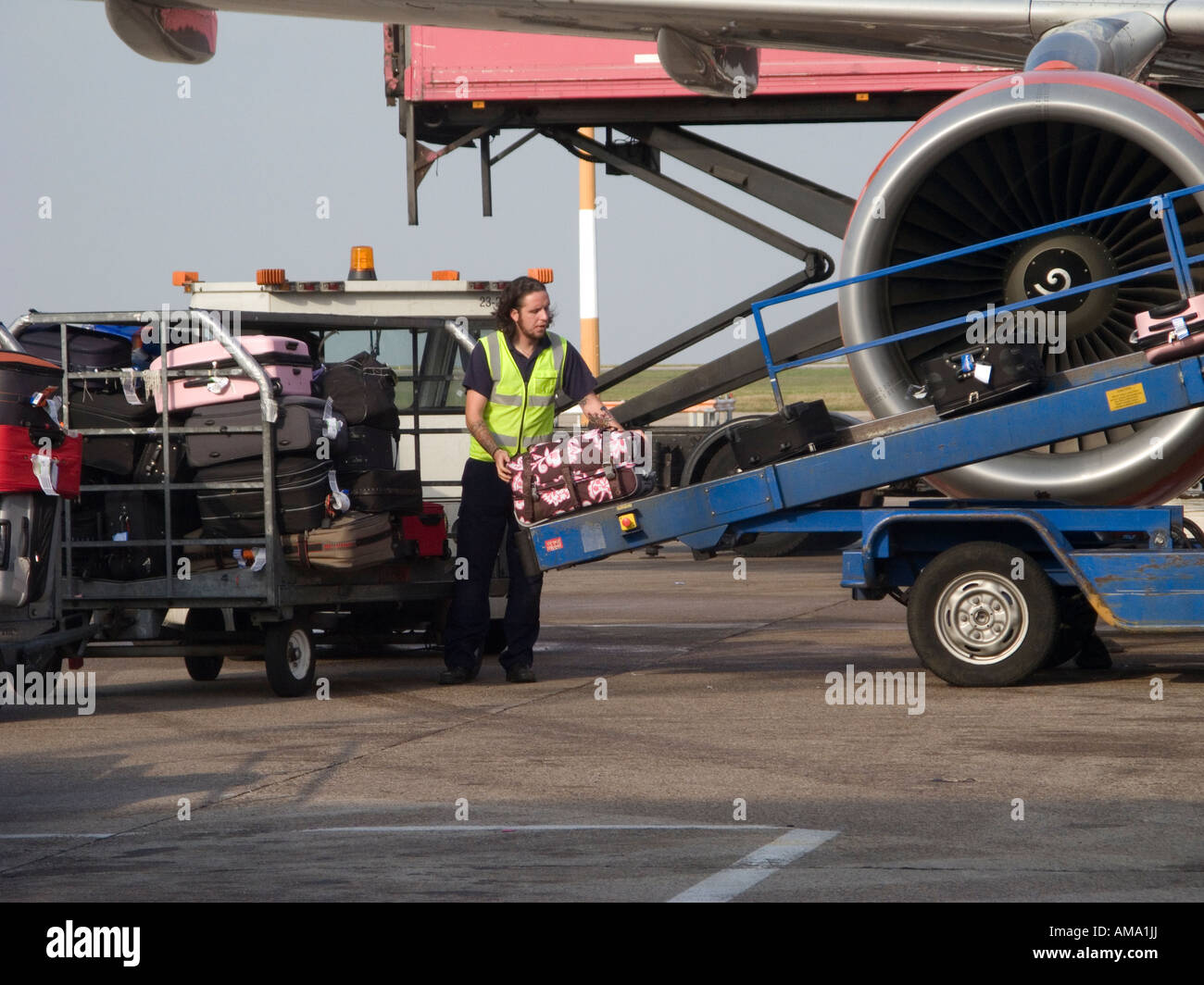 Baggage handler unloading airplane at East Midlands Airport Stock Photo