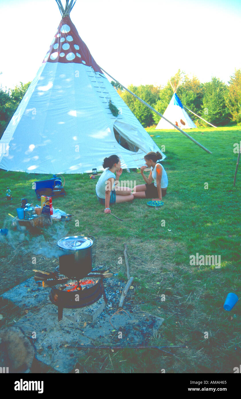 two people outside tipi in green field Sussex Tipi Holidays Sculdown Vineyard Broad Oak East Sussex UK Stock Photo