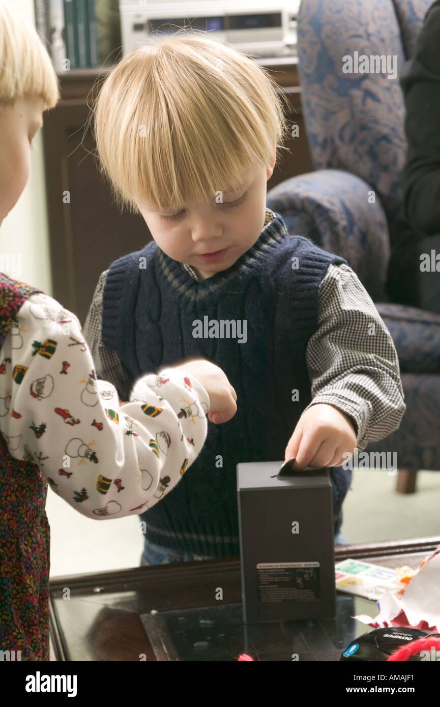 Young girl and boy Young boy putting money into piggy bank Stock Photo ...
