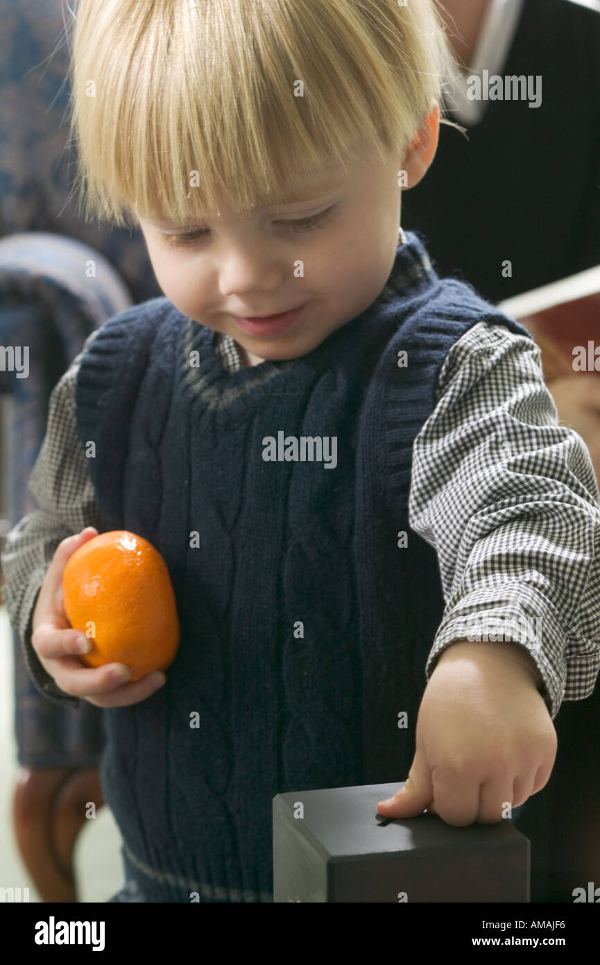 Young boy putting money into piggy bank Stock Photo - Alamy