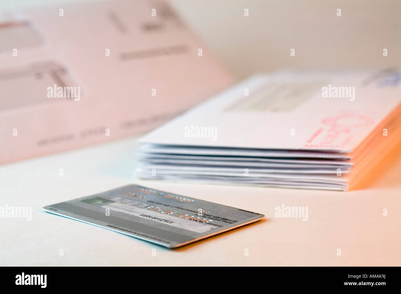 A credit card next to a stack of bills Stock Photo