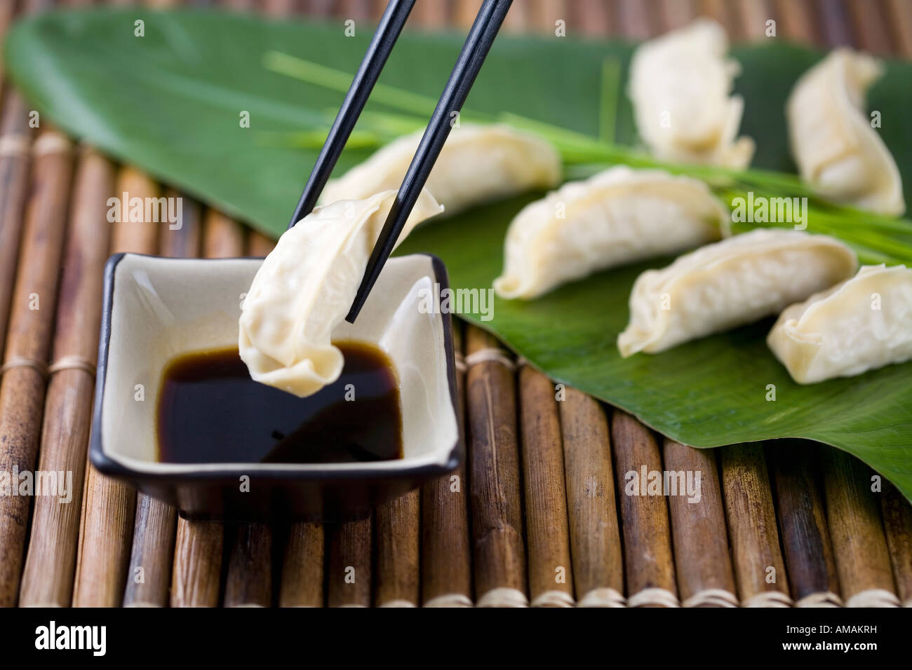 Chopsticks with Gyoza dumplings and soy sauce Stock Photo