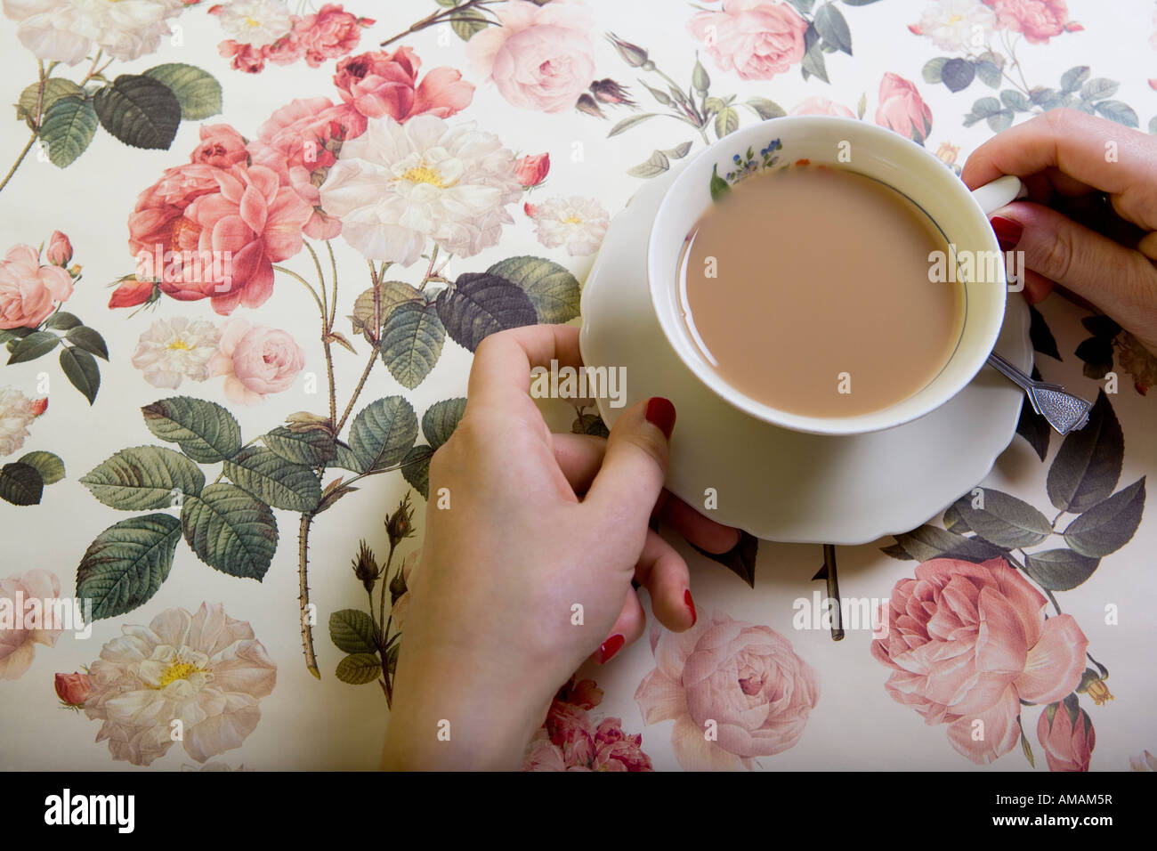 A cup of tea on a floral tablecloth Stock Photo