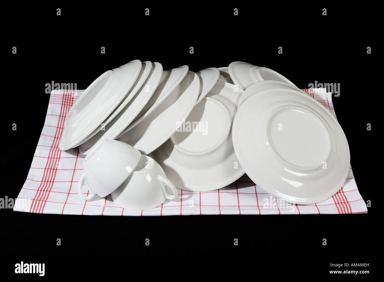 A stack of clean dishes on a dish towel Stock Photo Alamy