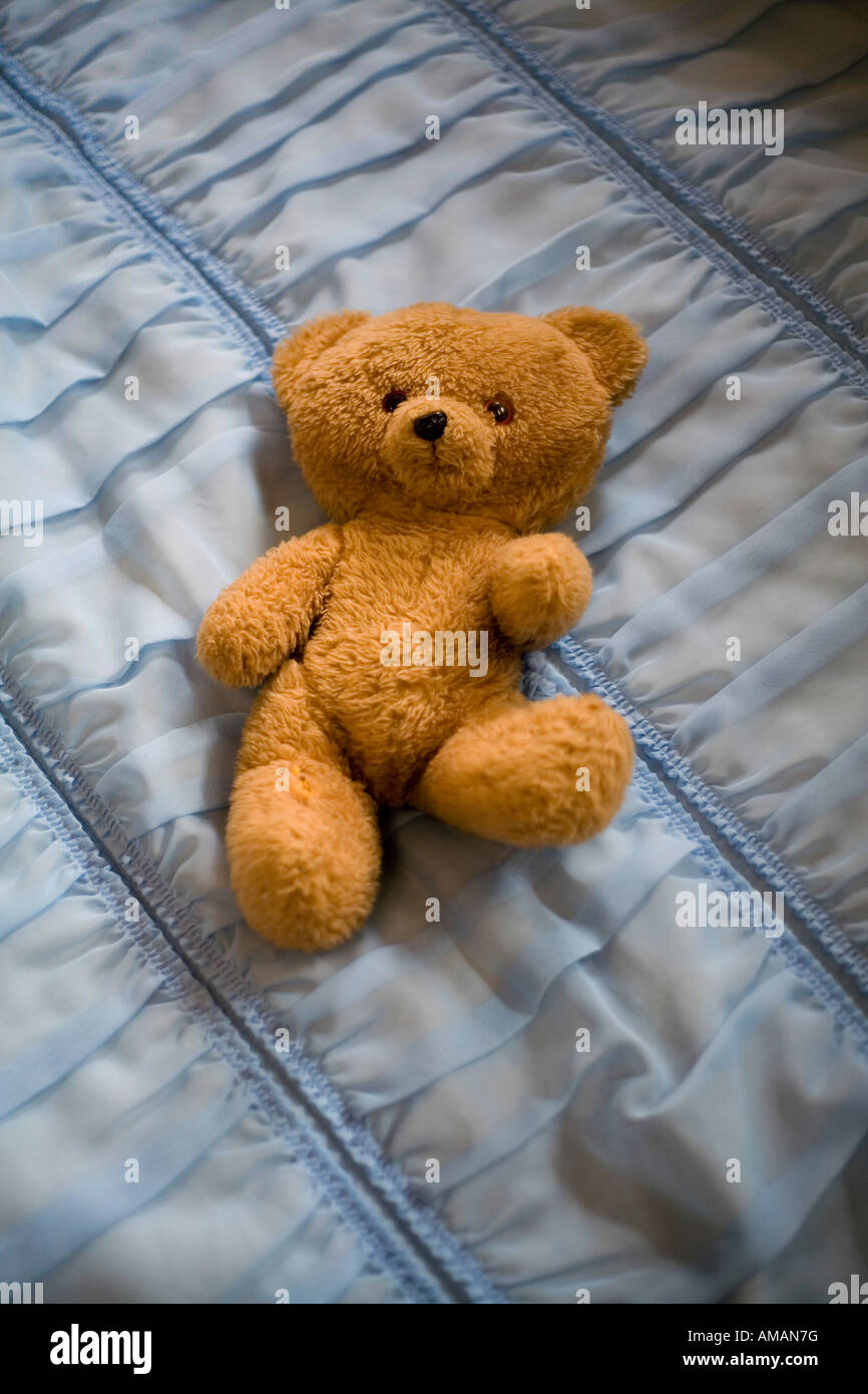 Teddy Bear on ruffled bed cover Stock Photo