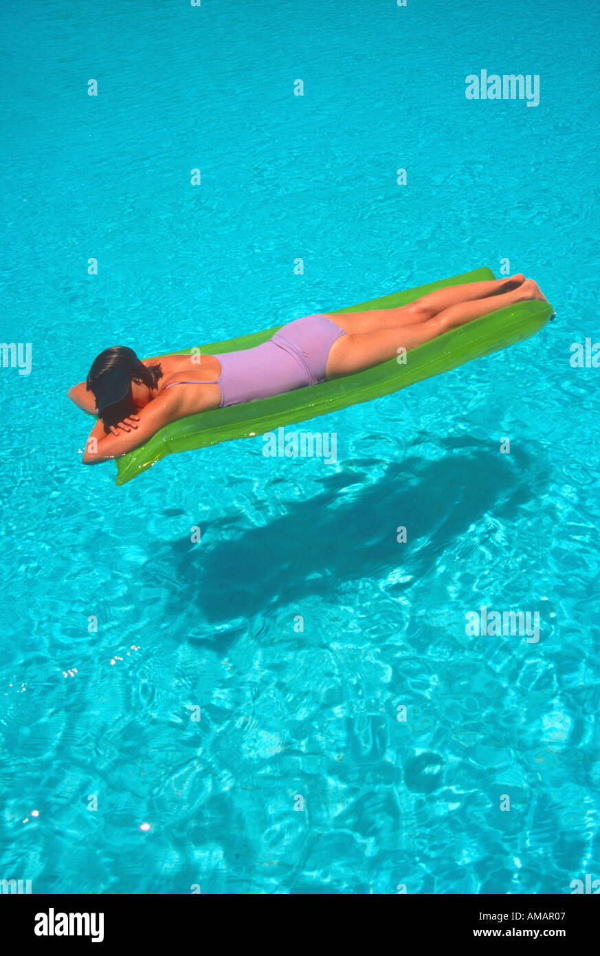 woman female floating on inflatable air bed lilo on water in bright