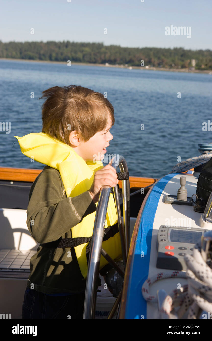 A boy steering a boat Stock Photo