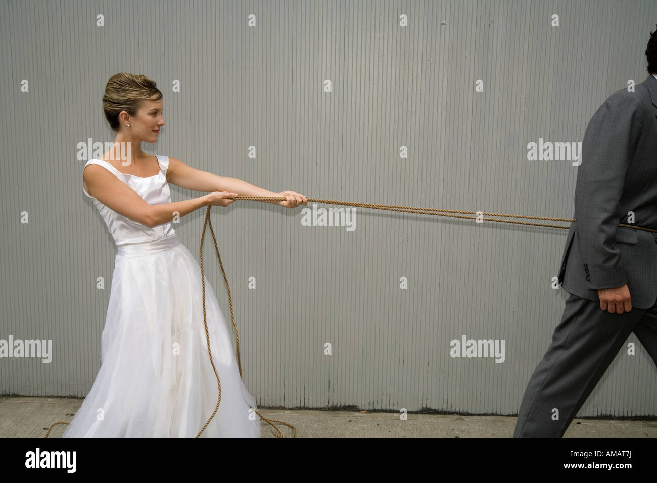 A bride pulling the groom with a rope Stock Photo