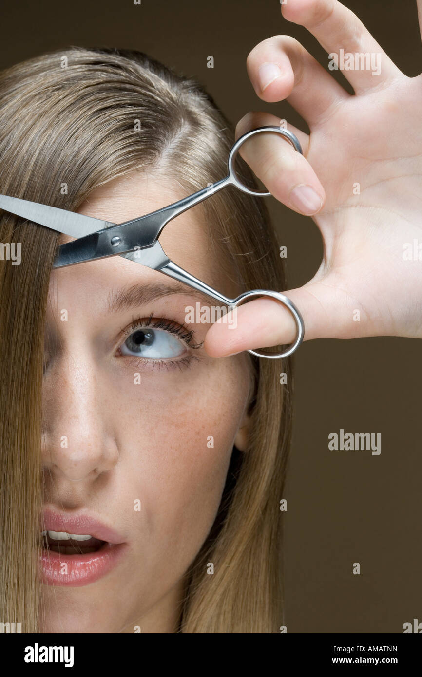 A woman cutting her hair Stock Photo - Alamy