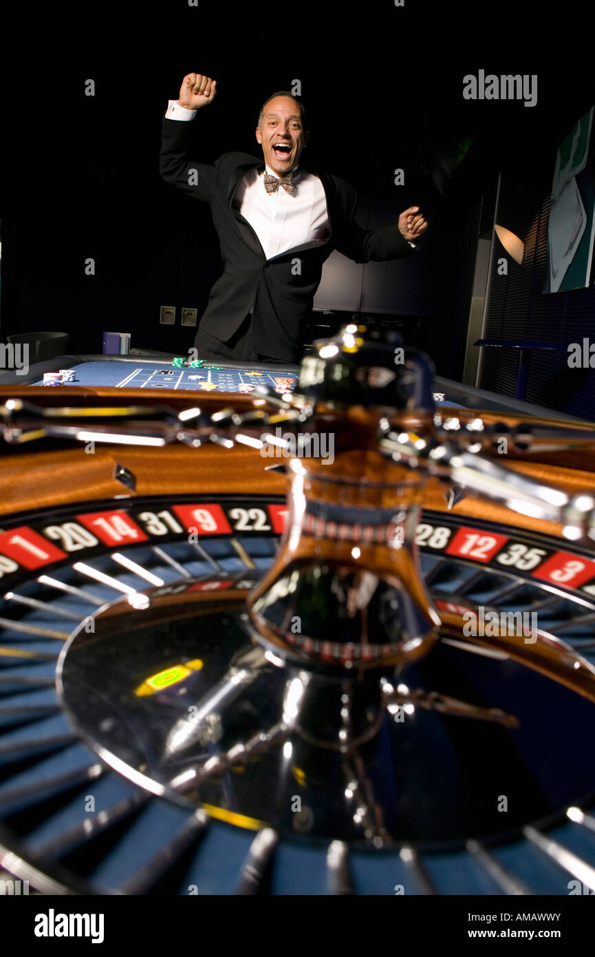 Roulette wheel with ecstatic man jumping Stock Photo