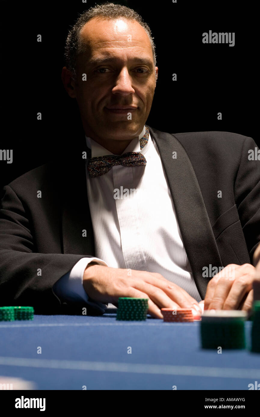 Well dressed man at casino table with serious facial expression Stock Photo