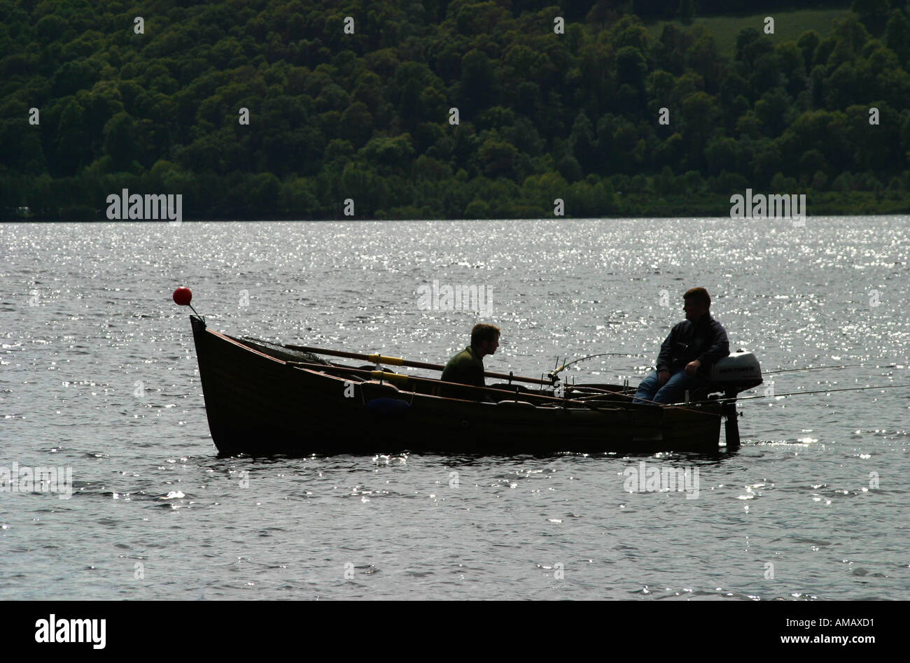 Anglers fishing from small wooden rowing boat on Loch Lomond Scotland Stock Photo