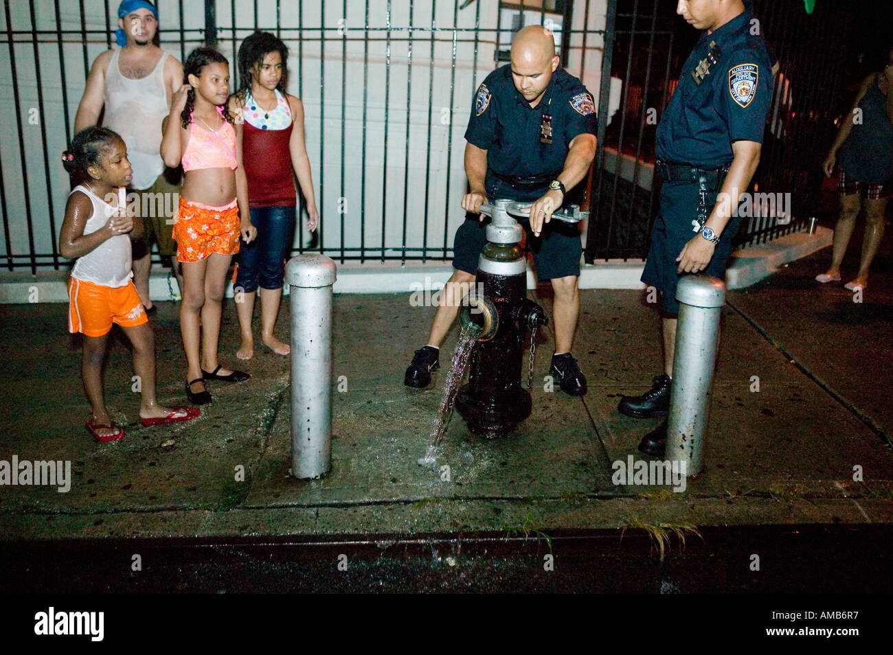 Police officers turn off an illegally opened fire hydrant in Harlem New York City USA August 2005 Stock Photo
