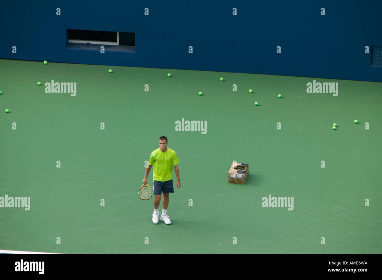 Yellow tennis balls accumulate behind a single tennisman during a practice game Flushing Meados New York 2005 Stock Photo