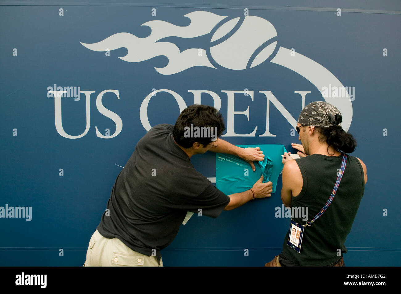 Workers install the logo on the back wall of the main court ahead of the 2005 US Tennis Open in Flushing Meadow USA August 2005 Stock Photo