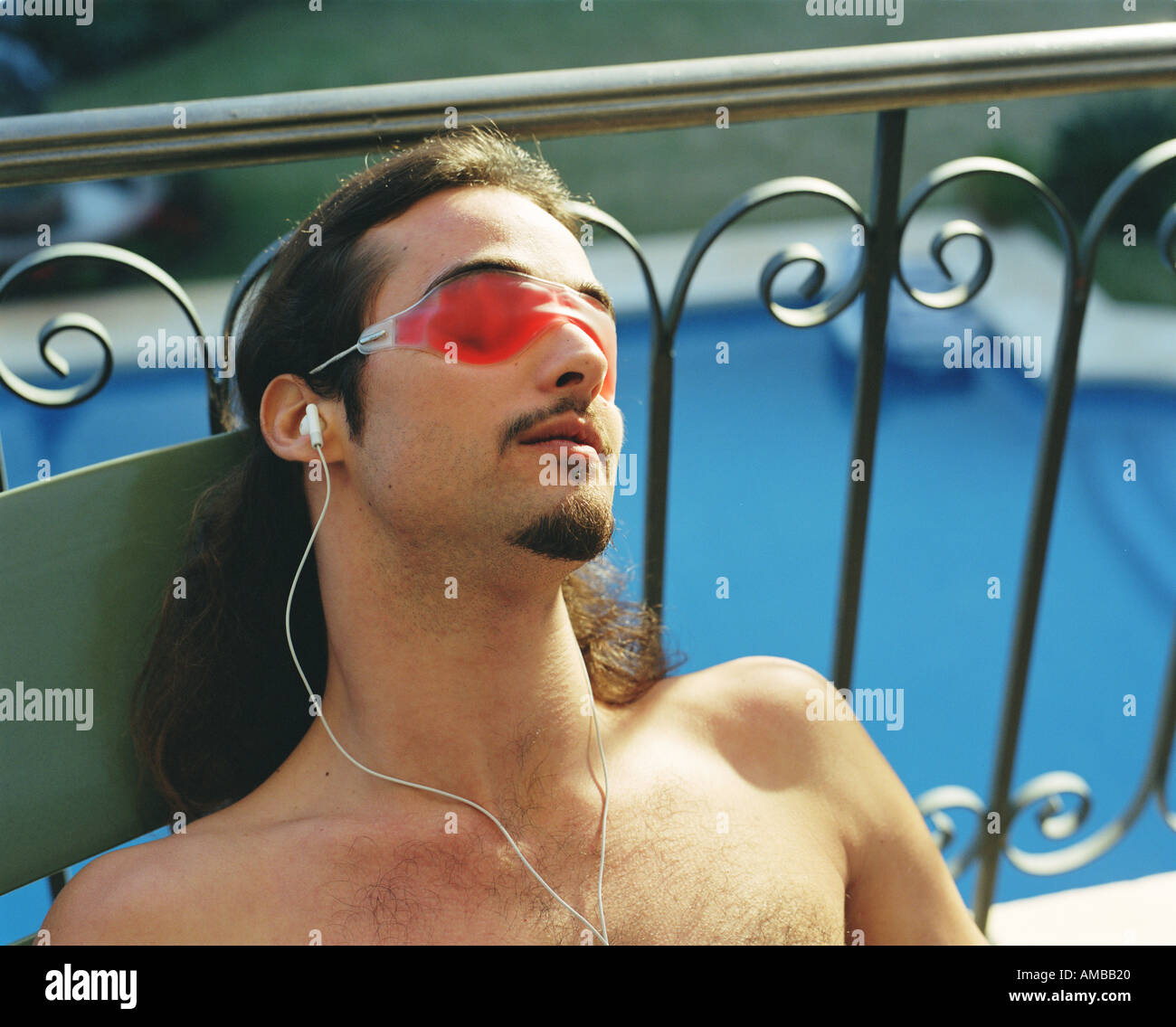 Man with eye mask relaxing in sun Stock Photo