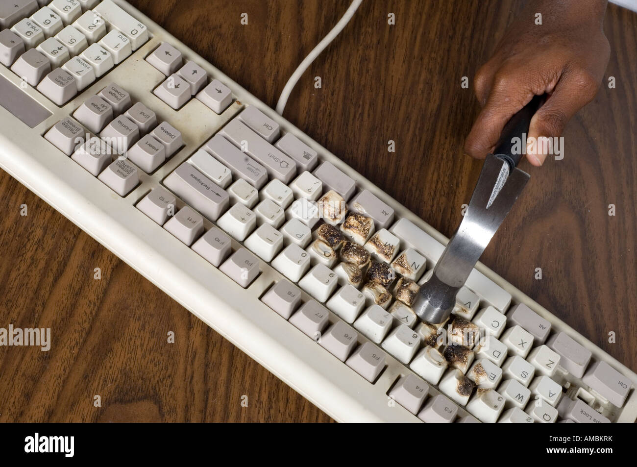 young boy breaking computer keyboard with a hammer Stock Photo Alamy