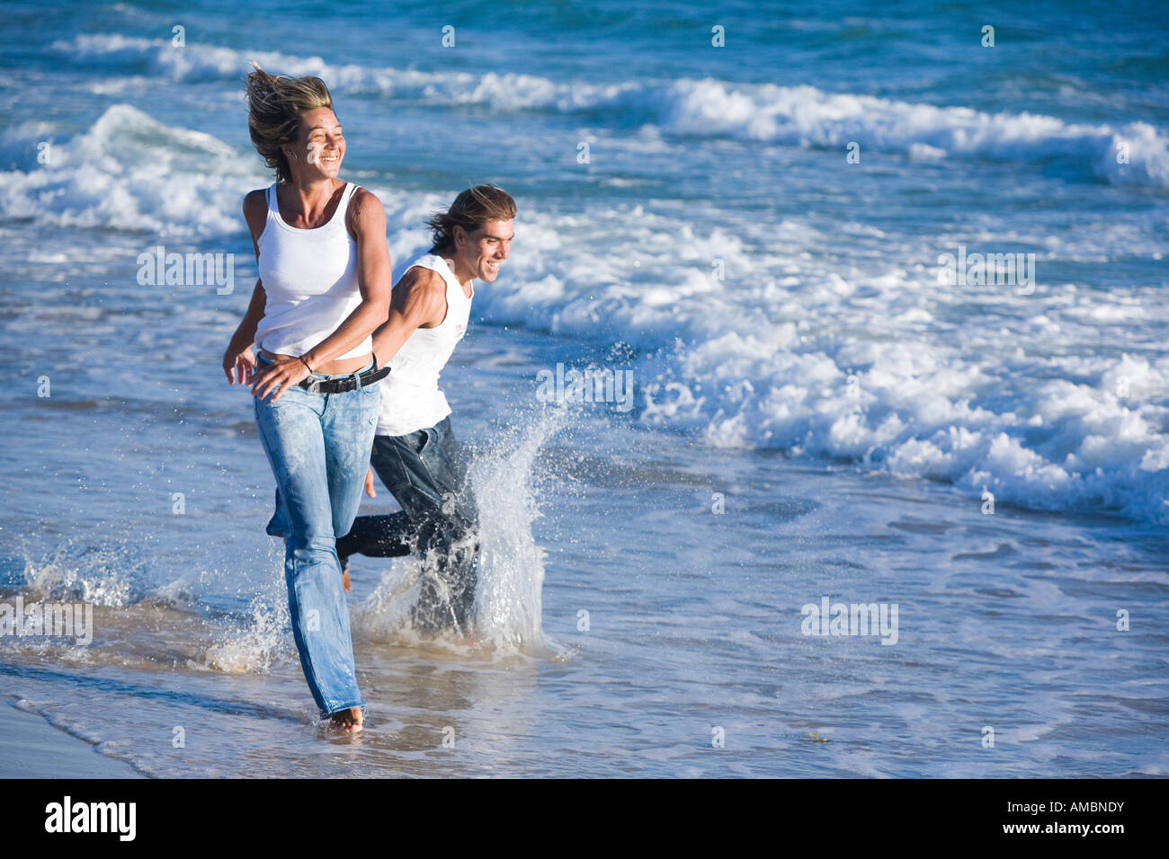 couple in jeans run on the sea shore Stock Photo Alamy