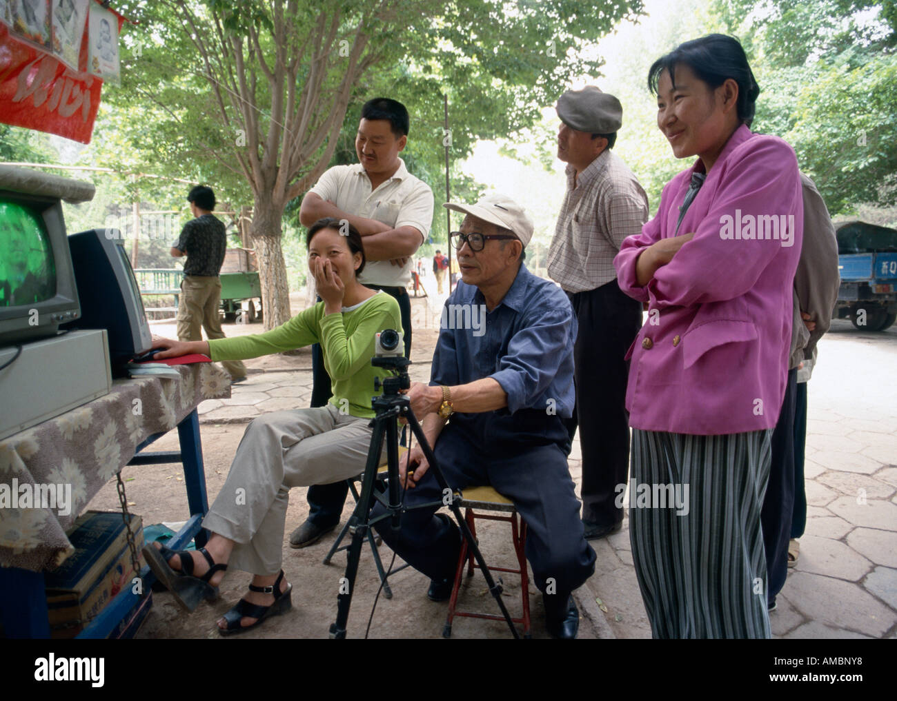 spectators watching video feed on television screen in state park, Kashgar, Xinjiang, China Stock Photo