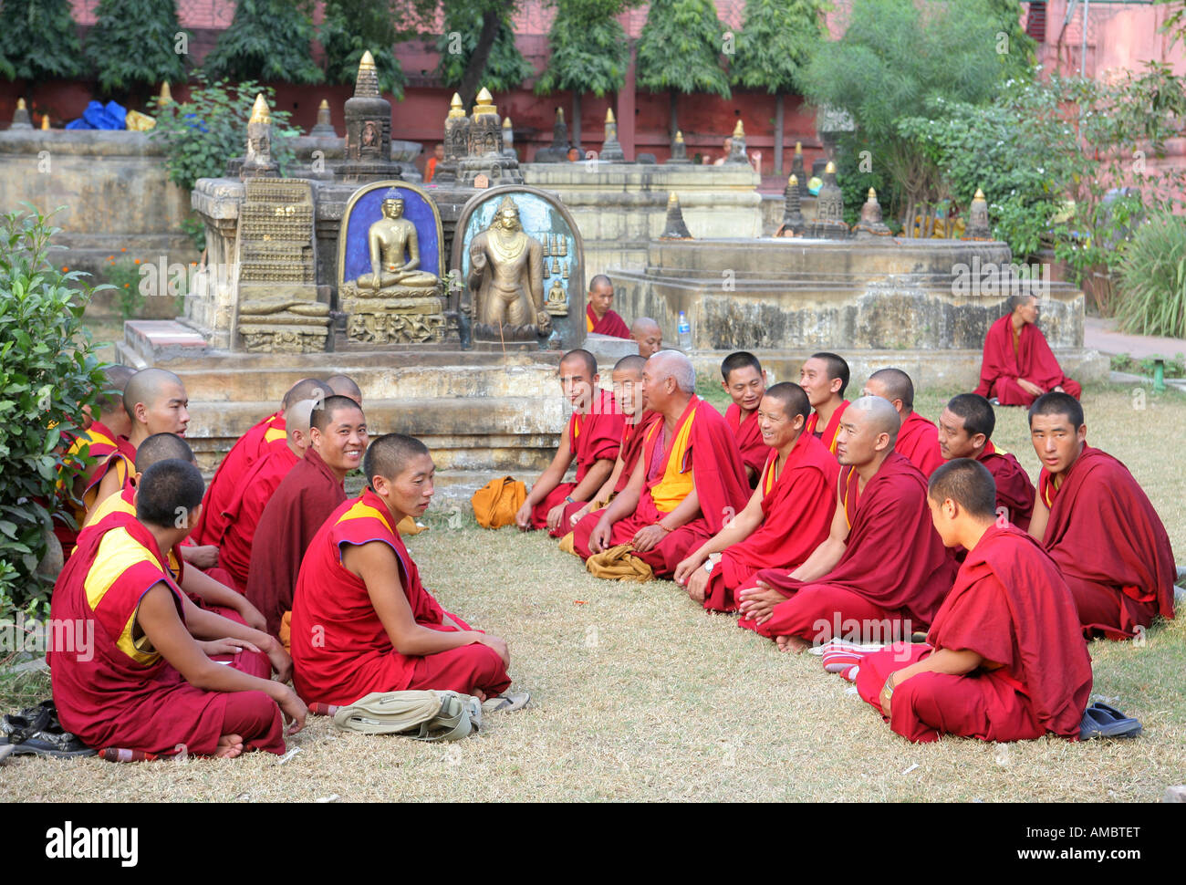 India, Bodhgaya: buddhist monks praying in the garden of Mahabodhi Temple, the place of the Buddha's Enlightenment Stock Photo