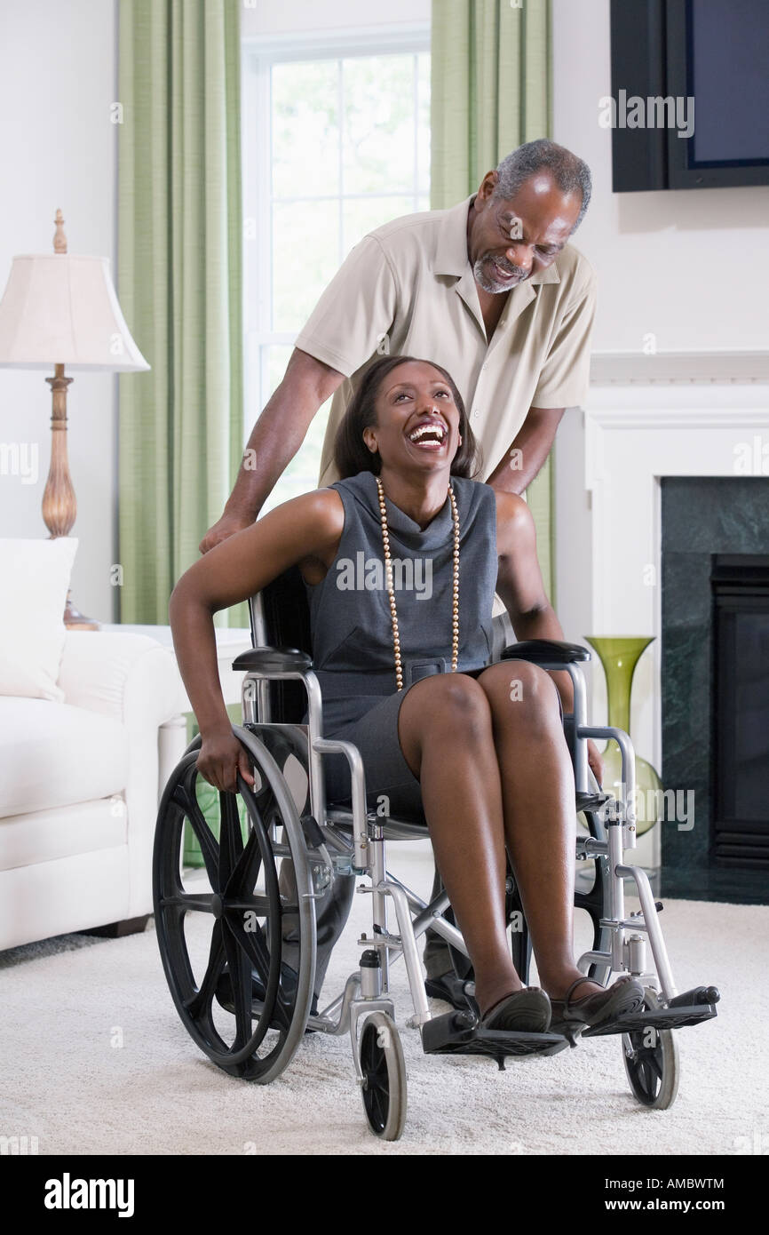 Middle-aged woman sitting in a wheelchair with a middle-aged man ...
