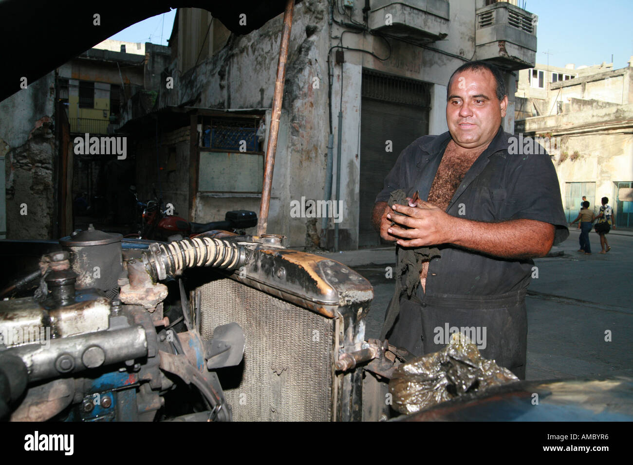 Havana Cuba a private taxi driver working on his 59year old classic car all original except the engine Stock Photo