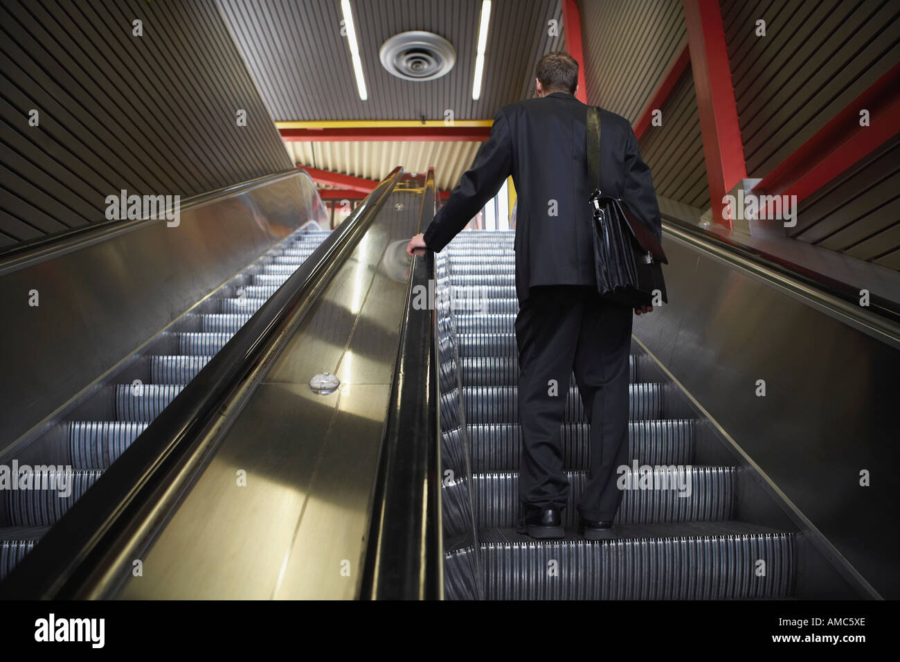 Businessman on Escalator Stock Photo
