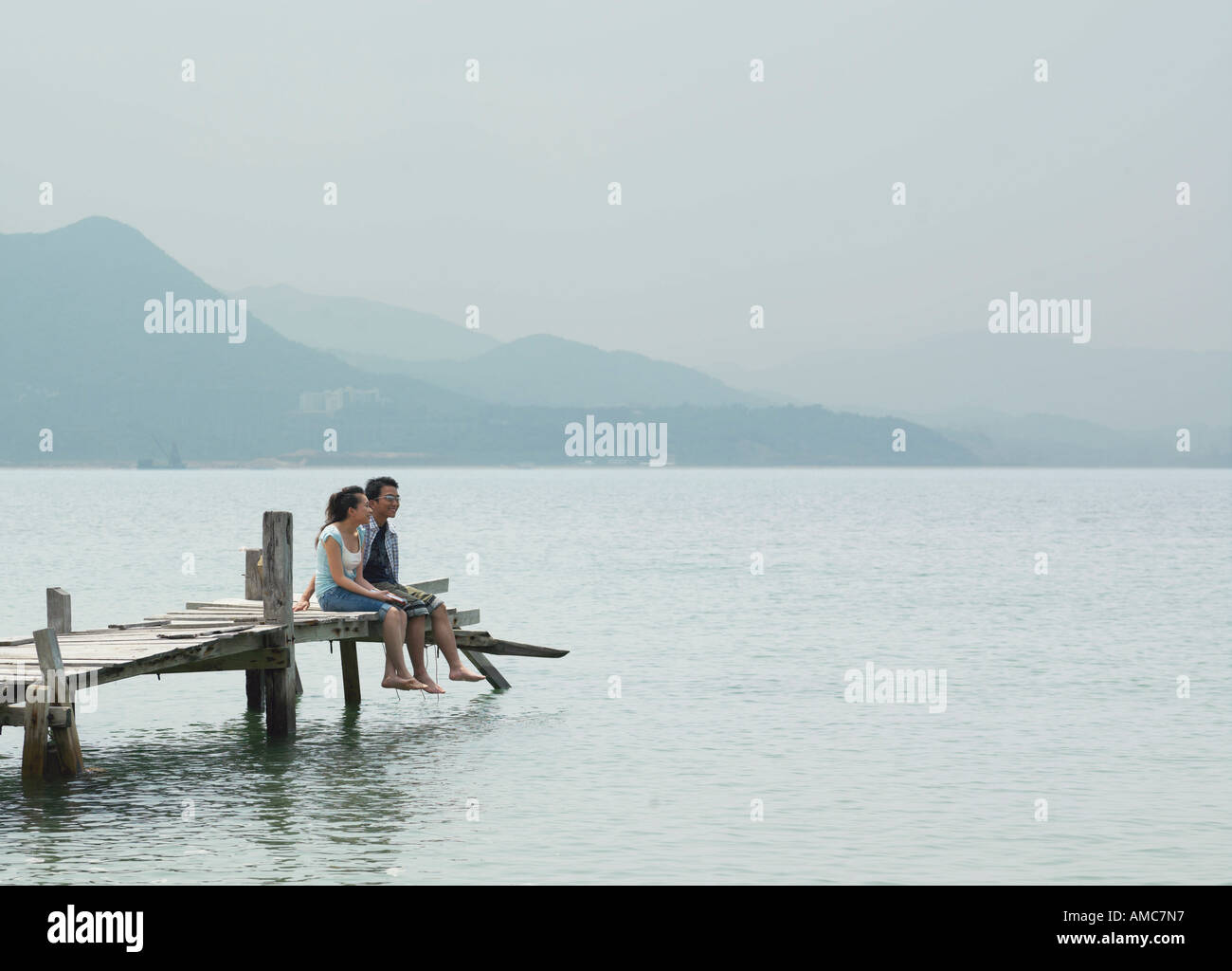 Couple Sitting on Dock Stock Photo