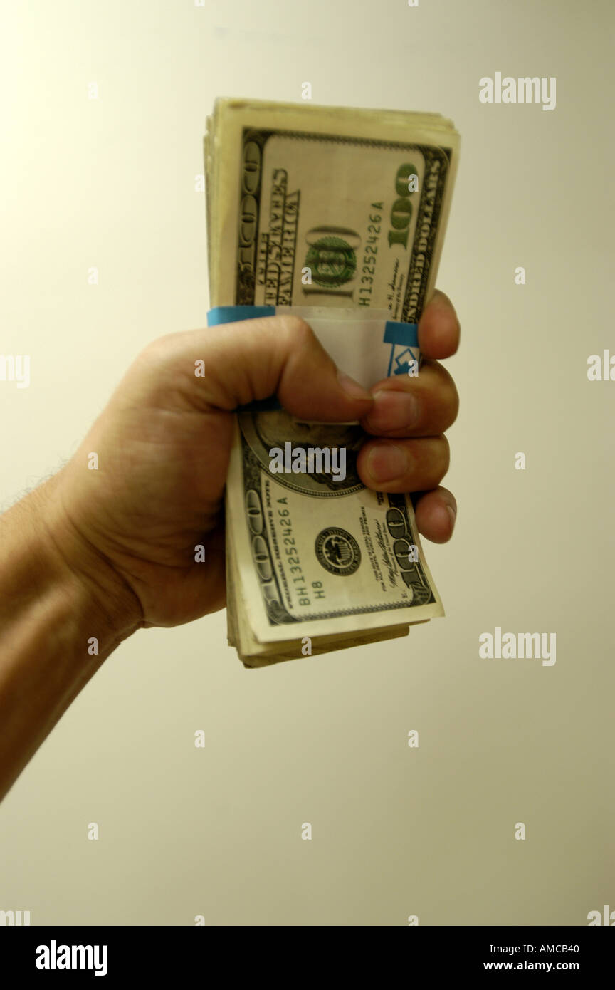 Left hand holding clutching money dollar paper bill Stock Photo