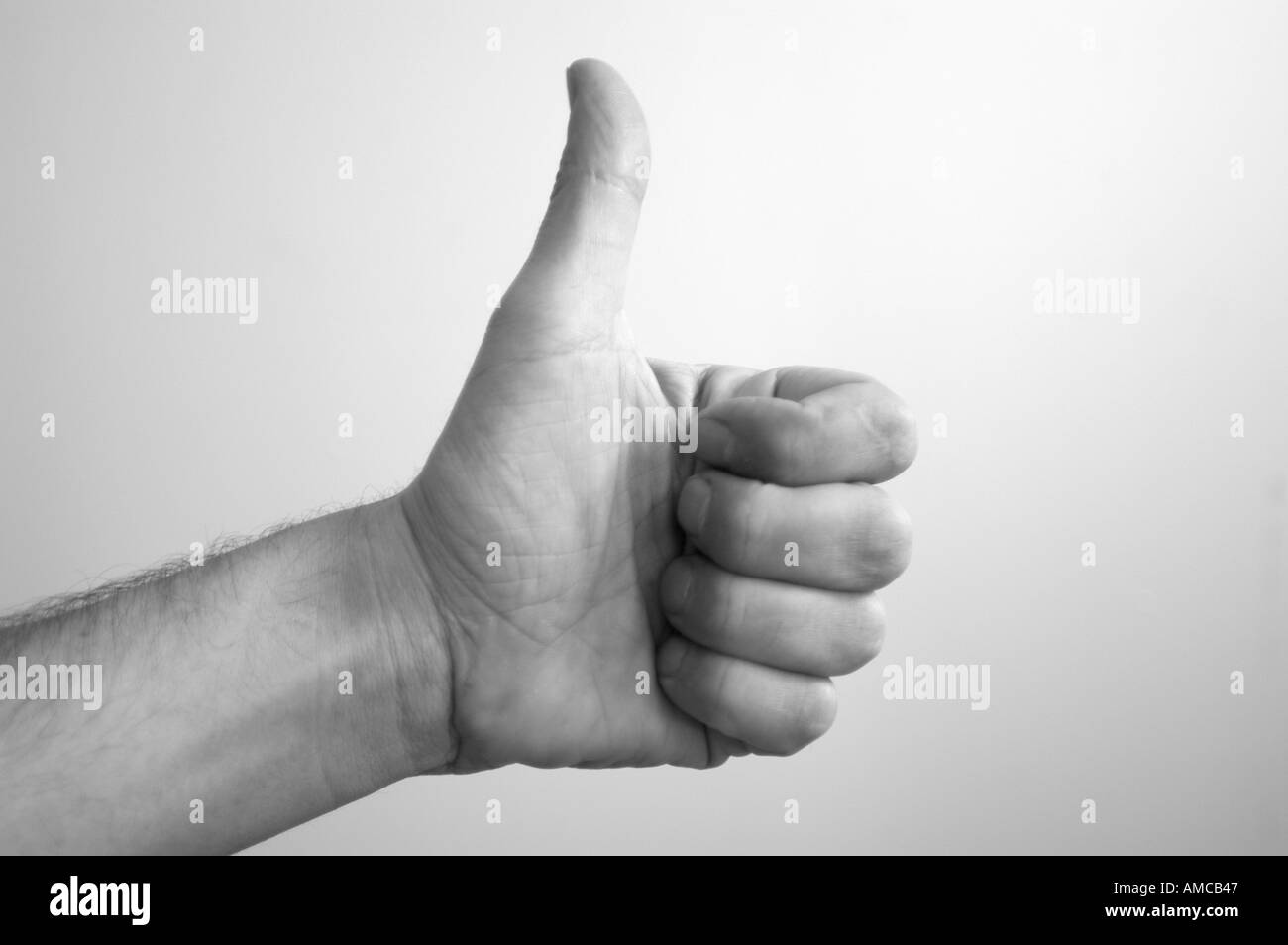 A hand with a thumb up, showing a positive non verbal expression. Stock Photo