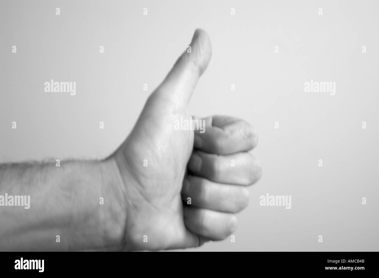 A hand with a thumb up, showing a positive non verbal expression. Stock Photo