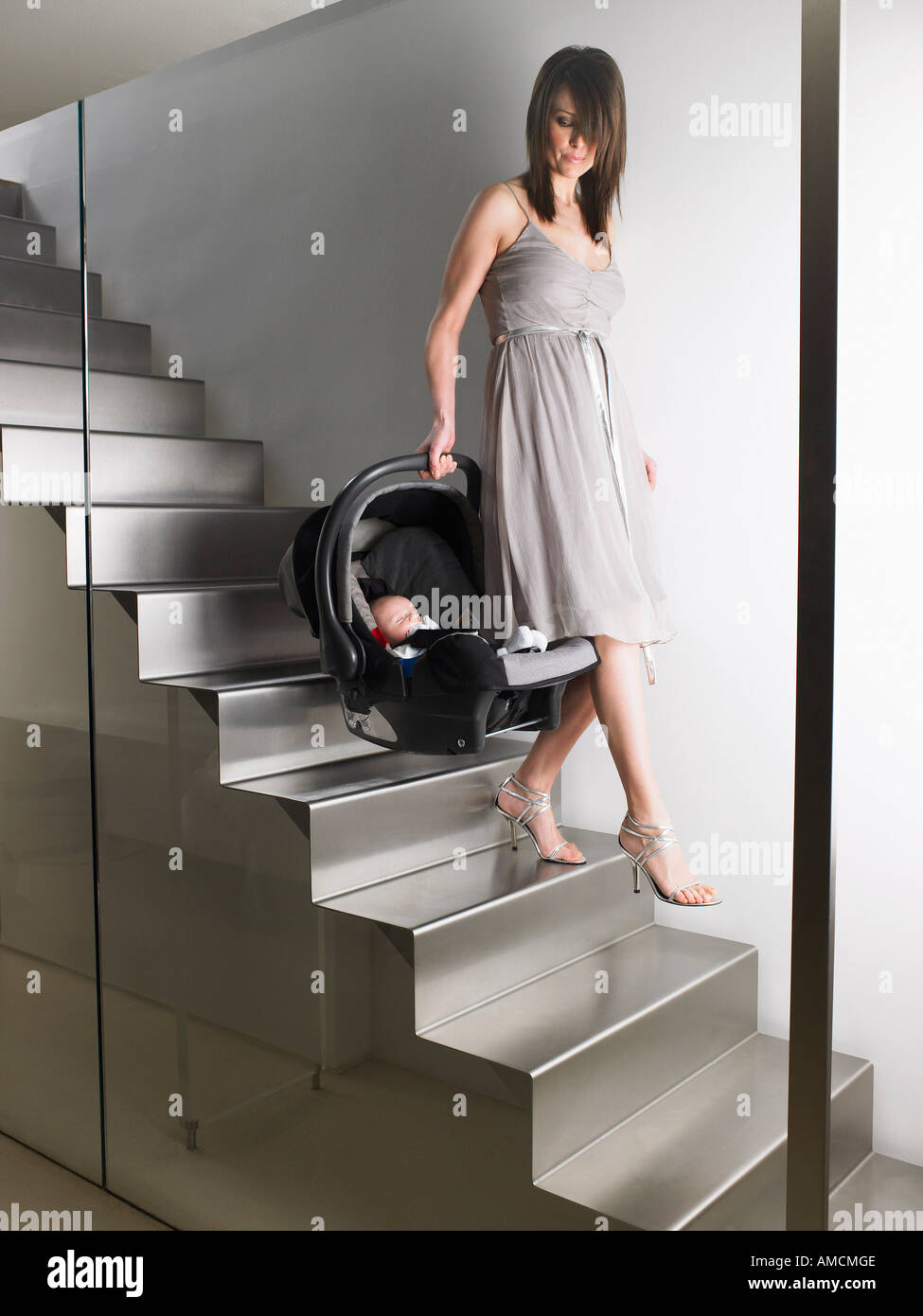 Woman Carrying Baby Seat down Stairs Stock Photo Alamy