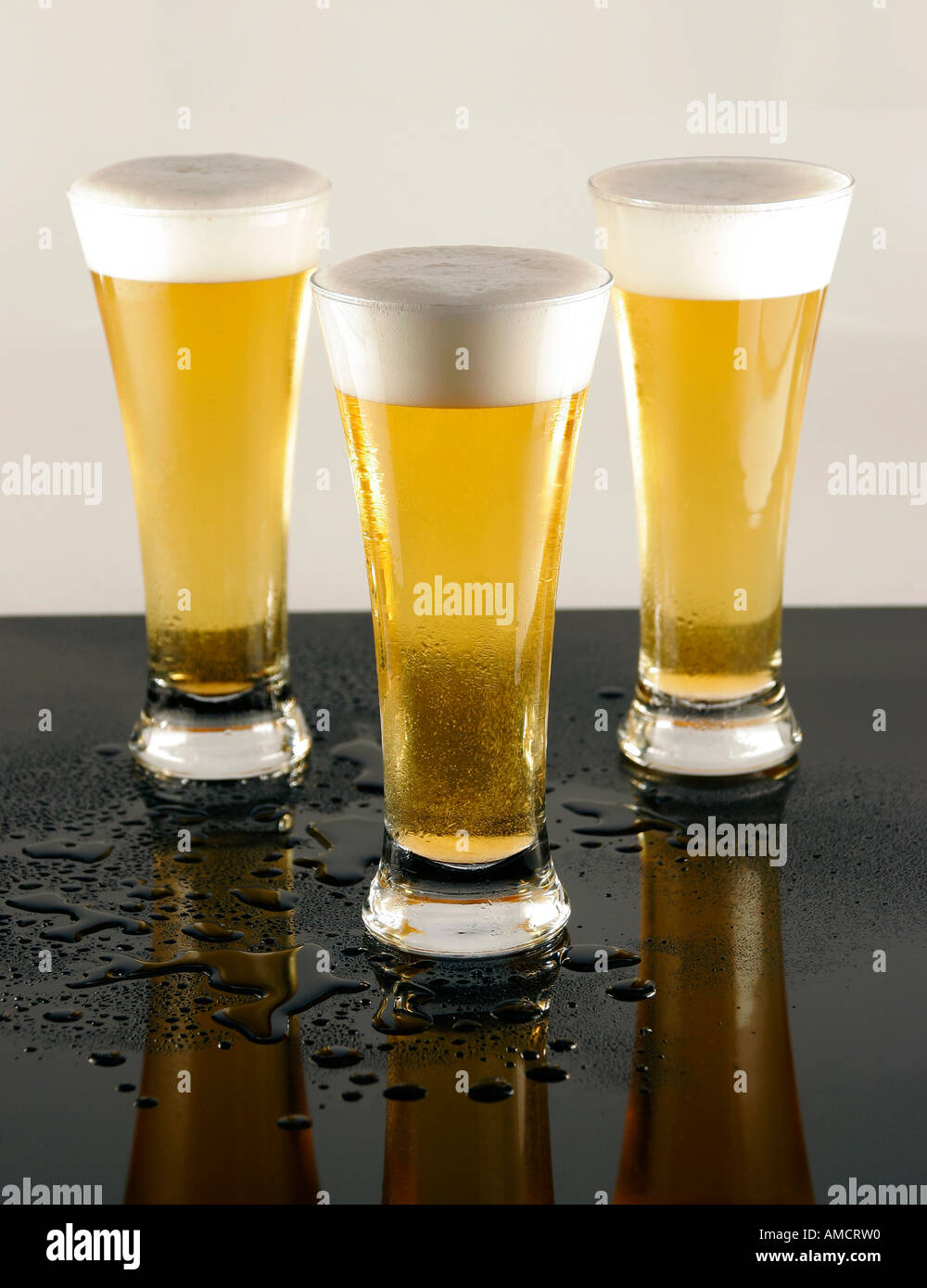 Three glasses of lager with foamy heads close up Stock Photo