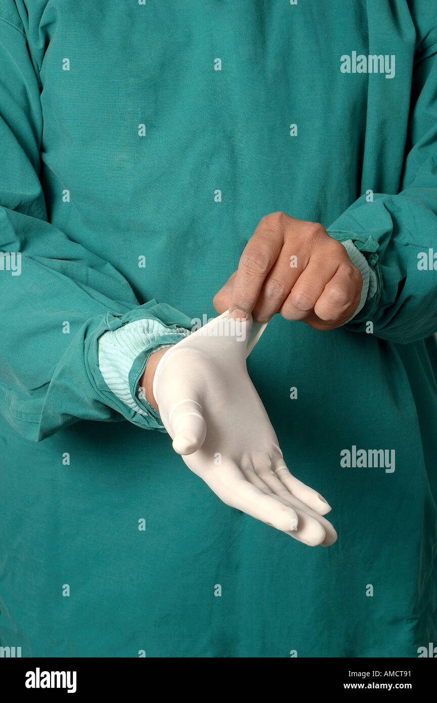 Young Indian Doctor surgeon in green overalls wearing white rubber latex surgical gloves only on hands Model Release Number 637 Stock Photo
