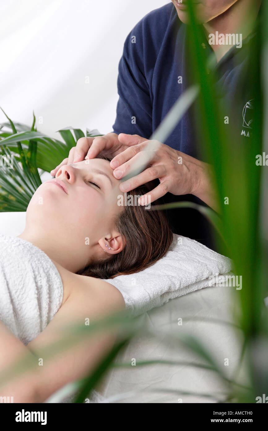 Young woman having temples massaged by man Stock Photo - Alamy