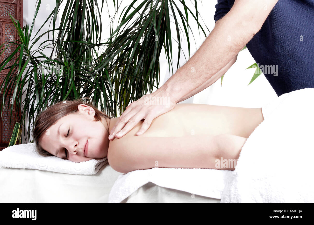 Young woman having back massage by man Stock Photo
