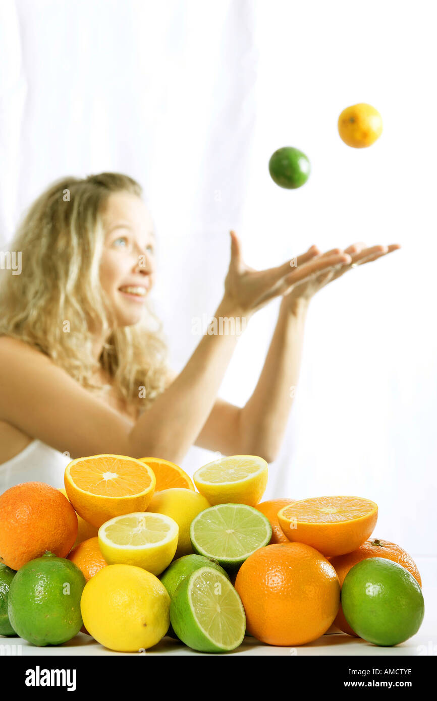 A girl playing with multicoloured lemons Stock Photo