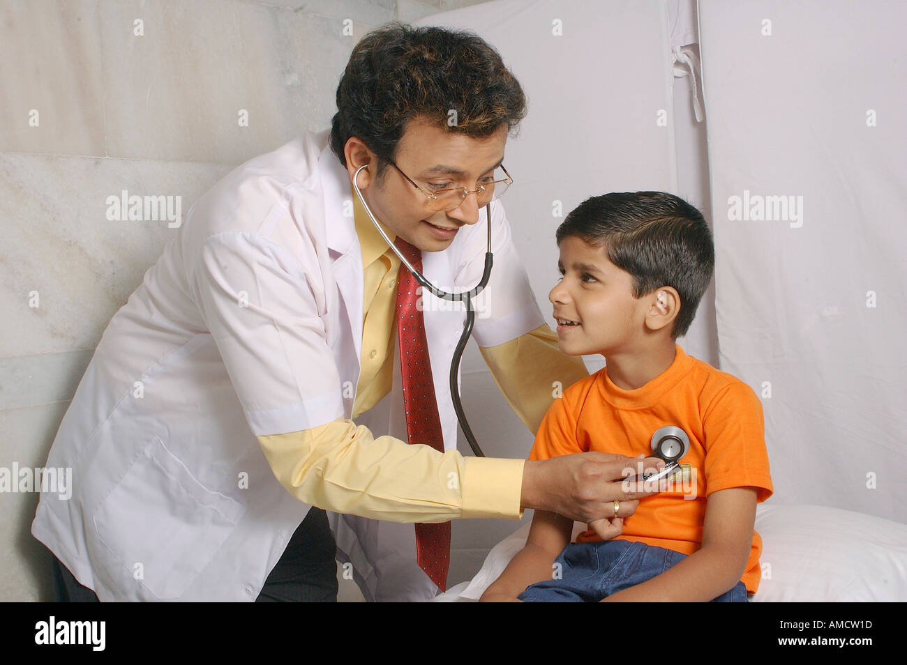 Indian Doctor Checking Small Boy Patient With Stethoscope In Clinic MR 