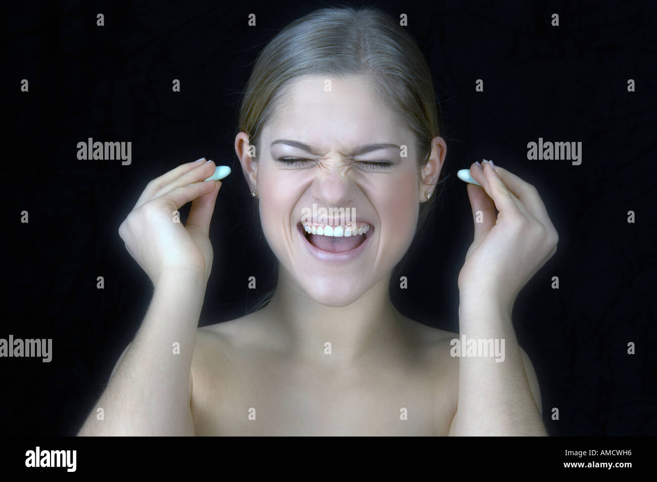 Woman putting ear plugs Stock Photo