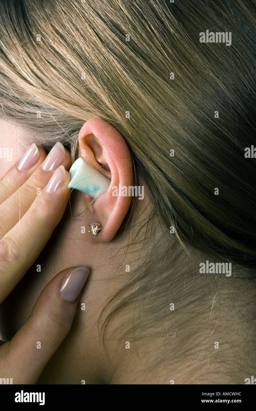 Woman putting ear plug Stock Photo Alamy