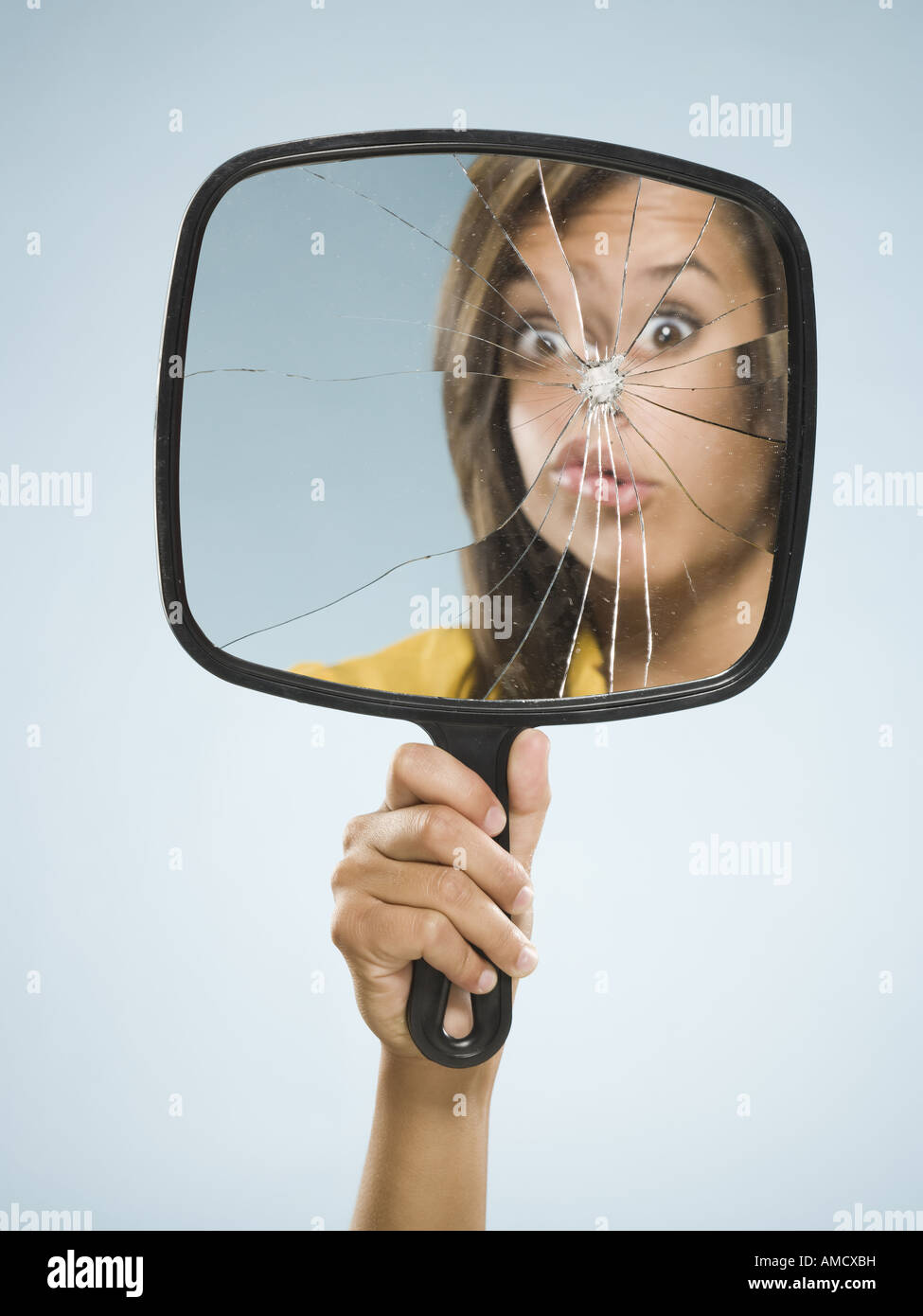 Reflection of woman in broken mirror Stock Photo